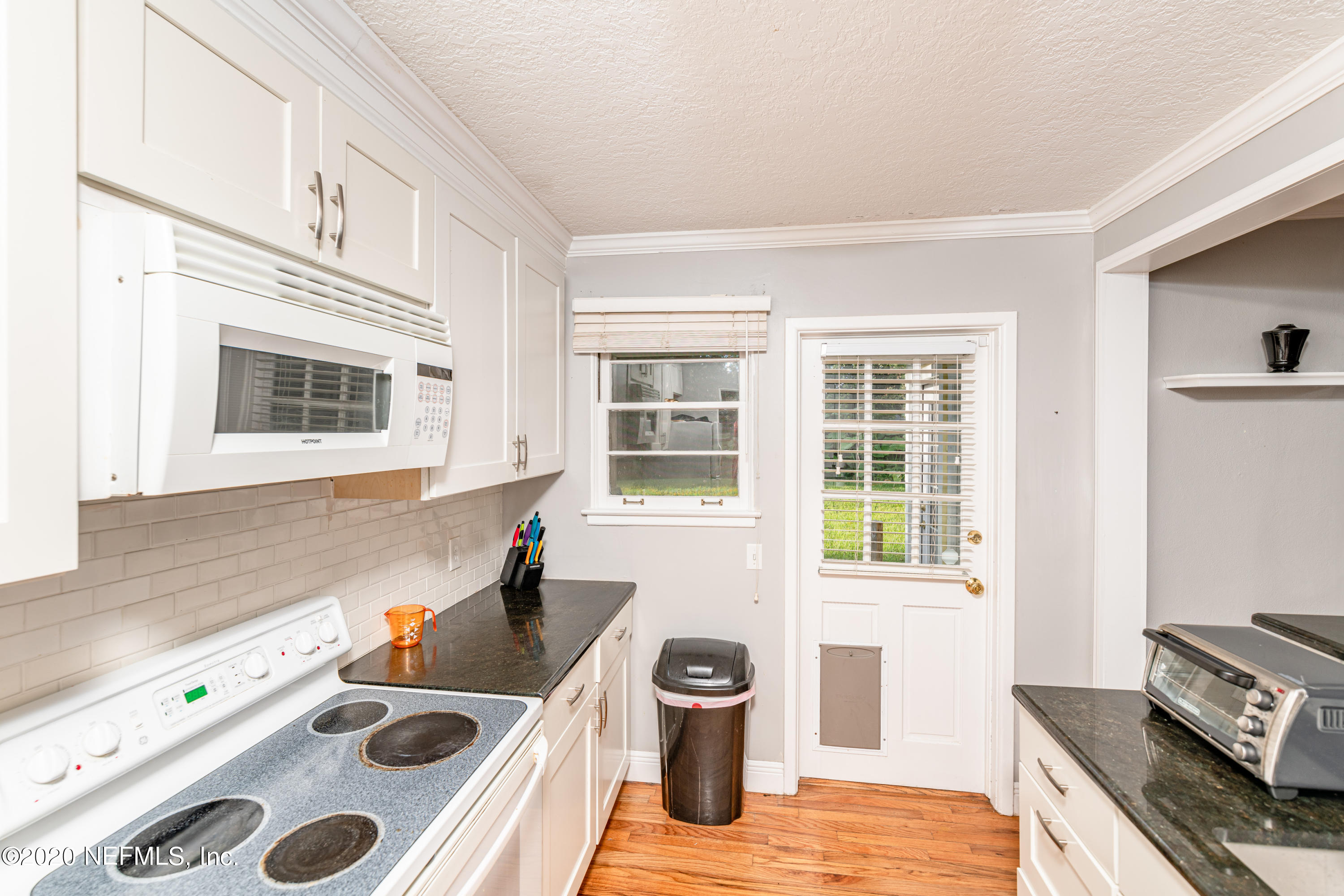 4615 Homestead Road Jacksonville, FL 32210 - Photo 11 of 41 a kitchen with a stove a sink and a microwave