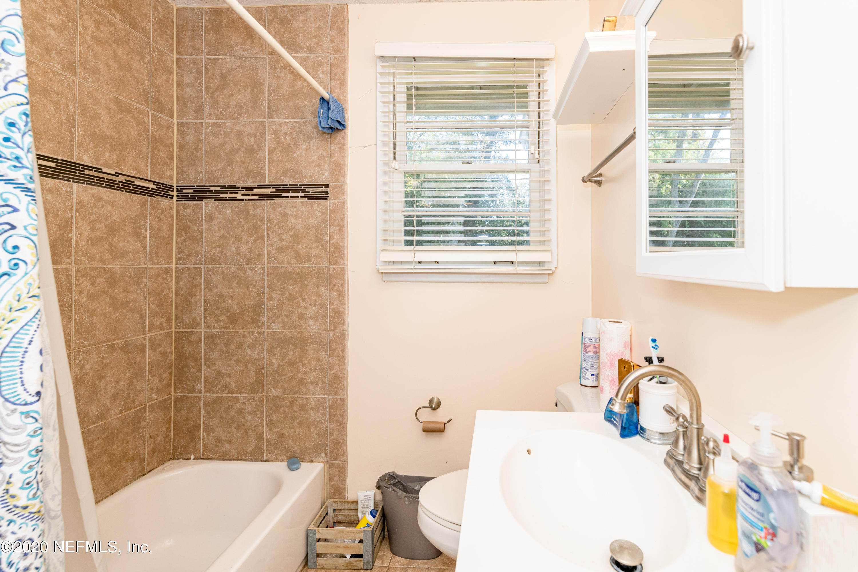4615 Homestead Road Jacksonville, FL 32210 - Photo 27 of 41 a white bath tub sitting next to a white sink and a shower