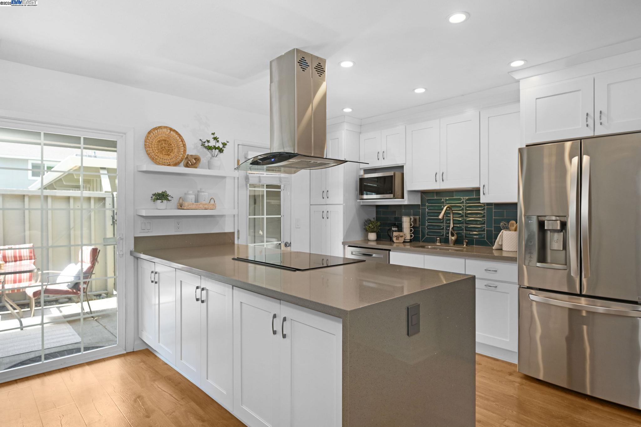 a kitchen with stainless steel appliances granite countertop a sink a stove and a refrigerator