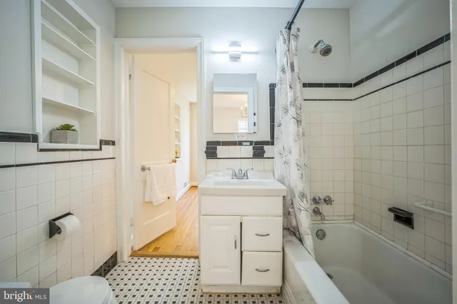 a bathroom with a sink a toilet a mirror and shower