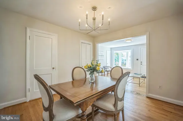 a view of a dining room with furniture a chandelier and wooden floor