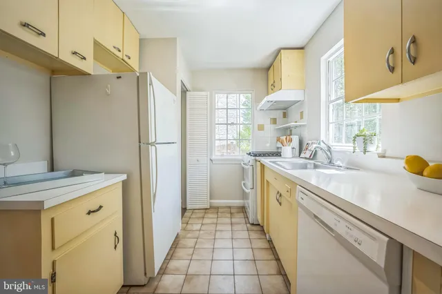 a kitchen with a sink a stove cabinets and a refrigerator