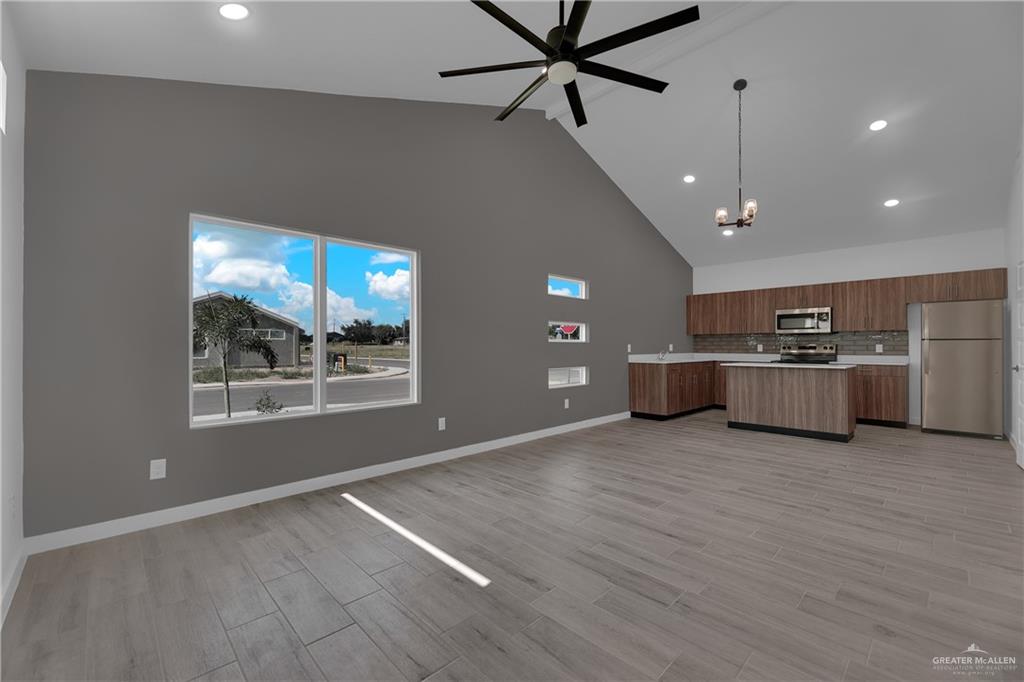 2509 Mockingbird Road, Unit B Weslaco, TX 78596 - Photo 2 of 11 Kitchen with high vaulted ceiling, ceiling fan with notable chandelier, light hardwood / wood-style flooring, decorative light fixtures, and appliances with stainless steel finishes