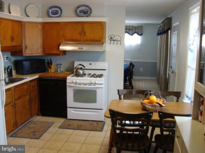 12818 Crisfield Road Silver Spring, MD 20906 - Photo 14 of 21 a kitchen with a stove a sink and a refrigerator