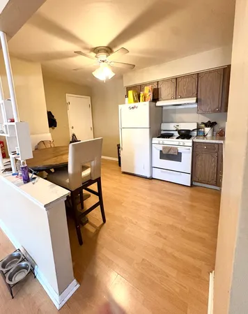 a kitchen with stainless steel appliances a stove a refrigerator a sink dishwasher and a stove with wooden floor