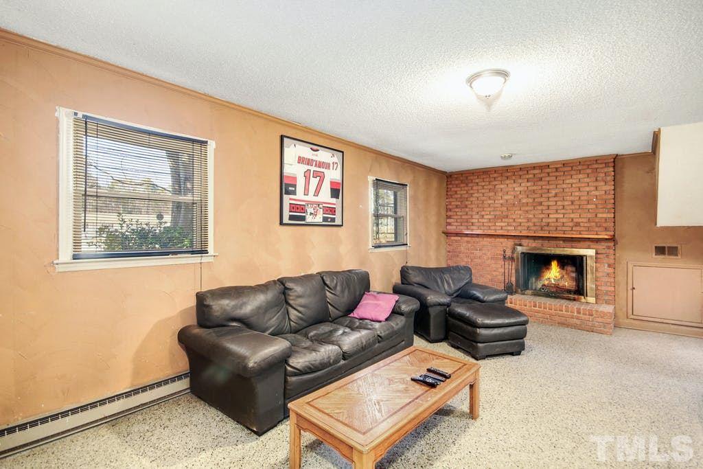 401 Buck Jones Road Raleigh, NC 27606 - Photo 11 of 21 a living room with furniture and a fireplace