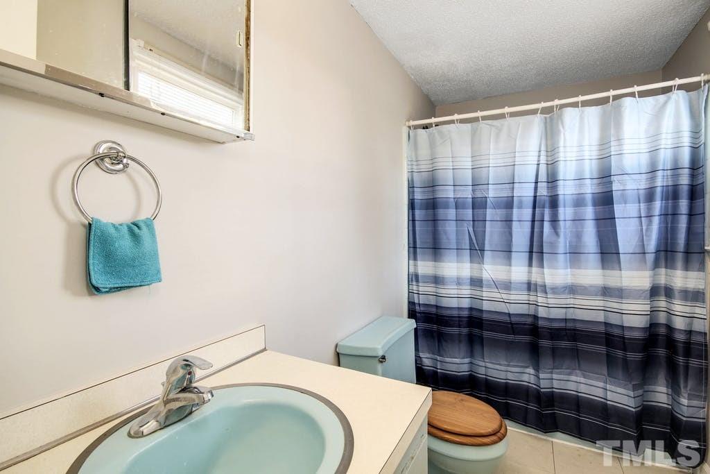 401 Buck Jones Road Raleigh, NC 27606 - Photo 13 of 21 a bathroom with a sink a toilet and shower