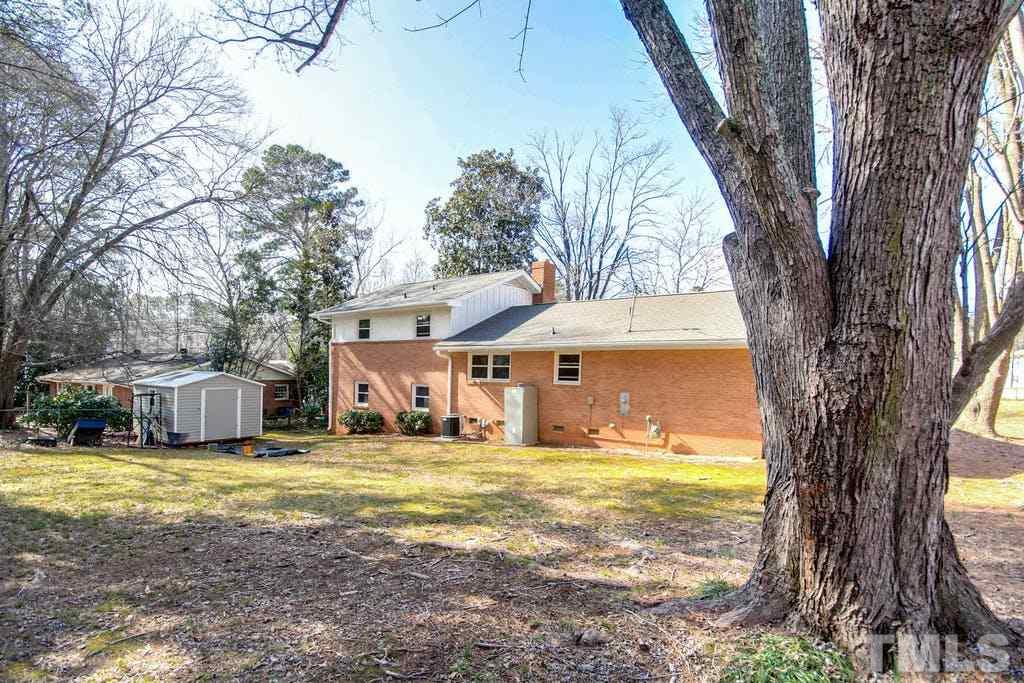 401 Buck Jones Road Raleigh, NC 27606 - Photo 21 of 21 a view of a house with a yard and large trees