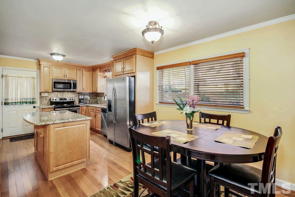 401 Buck Jones Road Raleigh, NC 27606 - Photo 9 of 21 a kitchen with stainless steel appliances granite countertop a stove a refrigerator a kitchen island a dining table and chairs