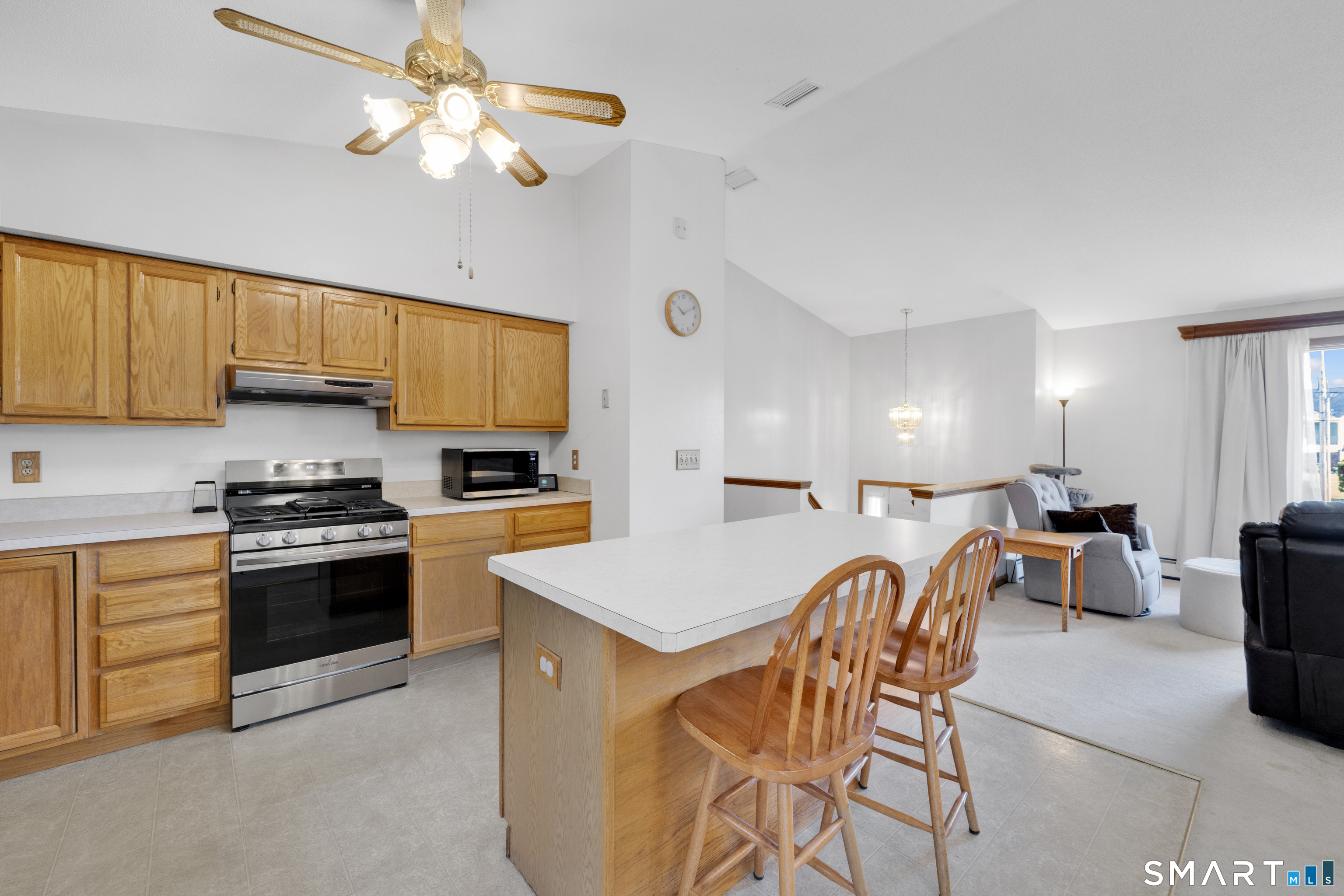357 North Maple Street Enfield, CT 06082 - Photo 15 of 37 a kitchen with stainless steel appliances granite countertop a stove top oven a sink a dining table and chairs with the cabinets