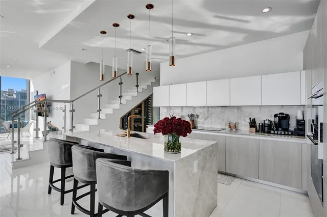 a kitchen with stainless steel appliances kitchen island a table and chairs in it