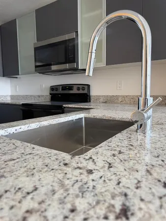 a kitchen with granite countertop a stove and a microwave