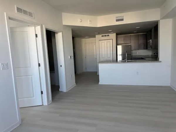 a view of a hallway with wooden floor and a cabinet