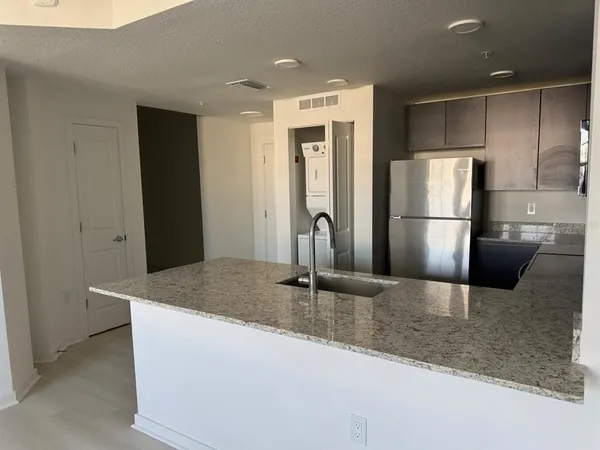 a kitchen with stainless steel appliances granite countertop a sink and a refrigerator
