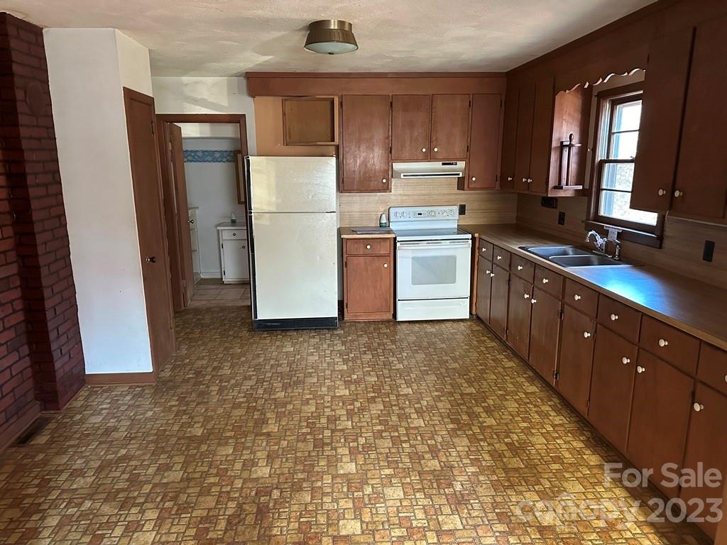 91 Beaver Street Tryon, NC 28782 - Photo 3 of 13 a kitchen with a refrigerator sink and cabinets