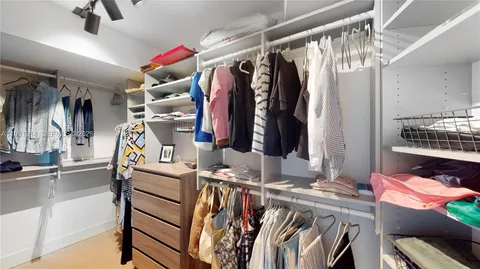 a view of walk in closet with clothes and shoes
