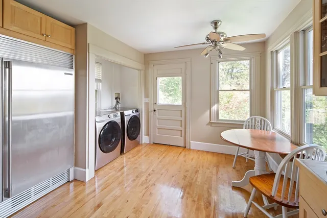a view of a room with wooden floor washing machine and windows