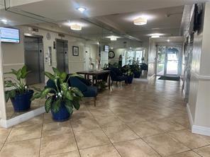 a lobby with furniture and potted plants