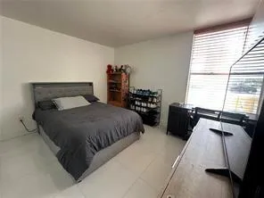 a bedroom with a bed a mirror and a window