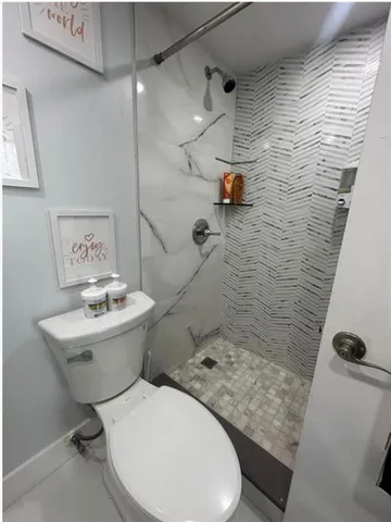 a view of bathroom with a sink mirror and toilet