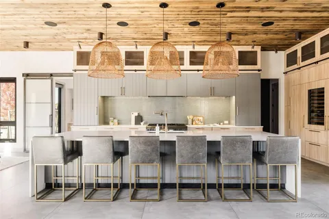 a kitchen with a dining table chairs and white appliances