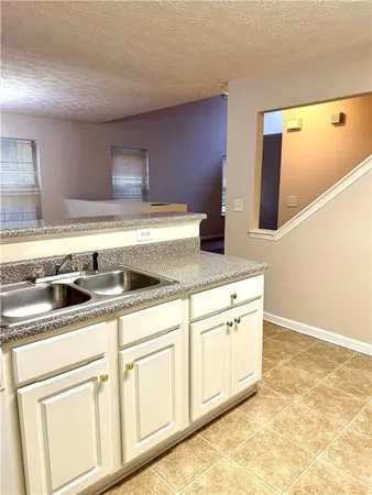 a kitchen with stainless steel appliances granite countertop a sink and a white cabinets