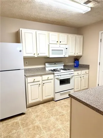 a kitchen with white cabinets and white appliances