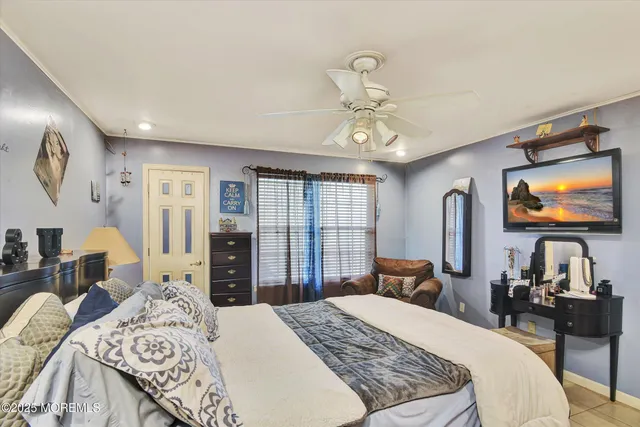 a bedroom with a bed and a flat tv screen on dresser