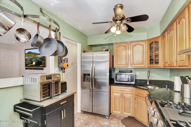 a kitchen with stainless steel appliances granite countertop a stove a refrigerator and a microwave