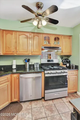 a kitchen with stainless steel appliances granite countertop a stove a sink and a microwave