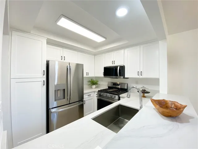 a kitchen with stainless steel appliances a refrigerator stove and microwave