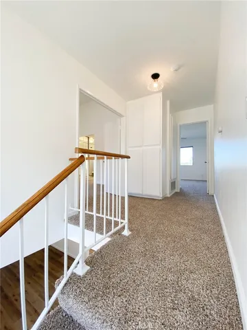 an empty room with a chandelier fan and windows