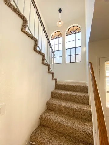 a table with a close to ceiling window and a chandelier
