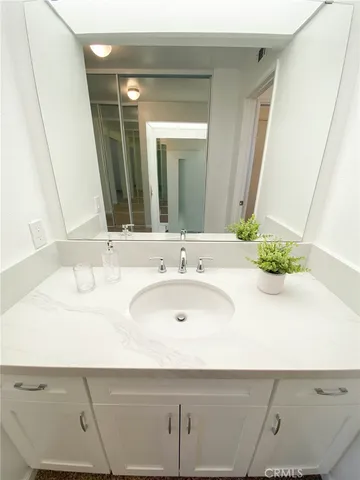 a spacious bathroom with a granite countertop sink and a mirror