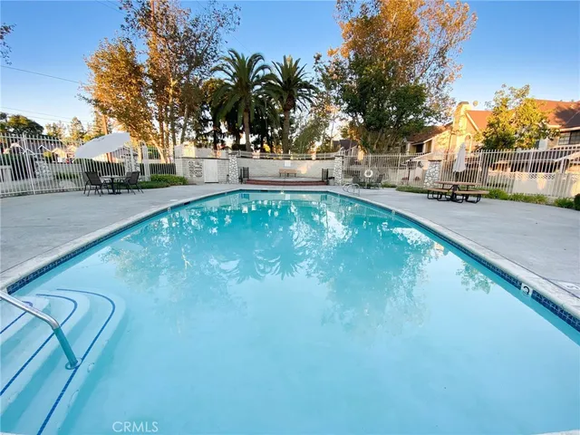 a view of a swimming pool with a patio and fire pit