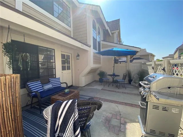 a view of a patio with table and chairs with wooden floor and fence