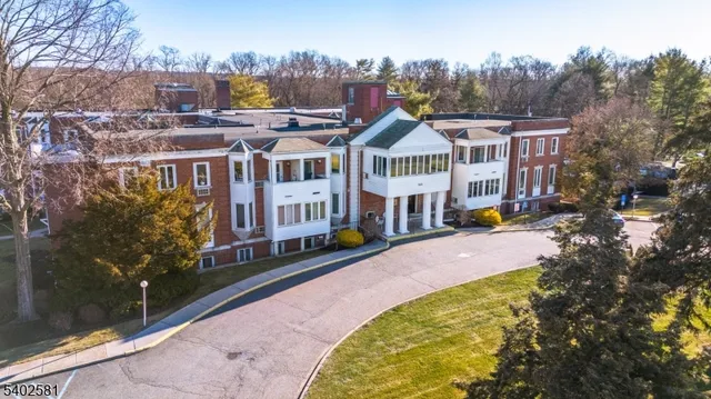 a front view of a house with a yard and large trees