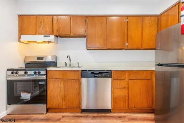 a kitchen with stainless steel appliances granite countertop a refrigerator and a sink
