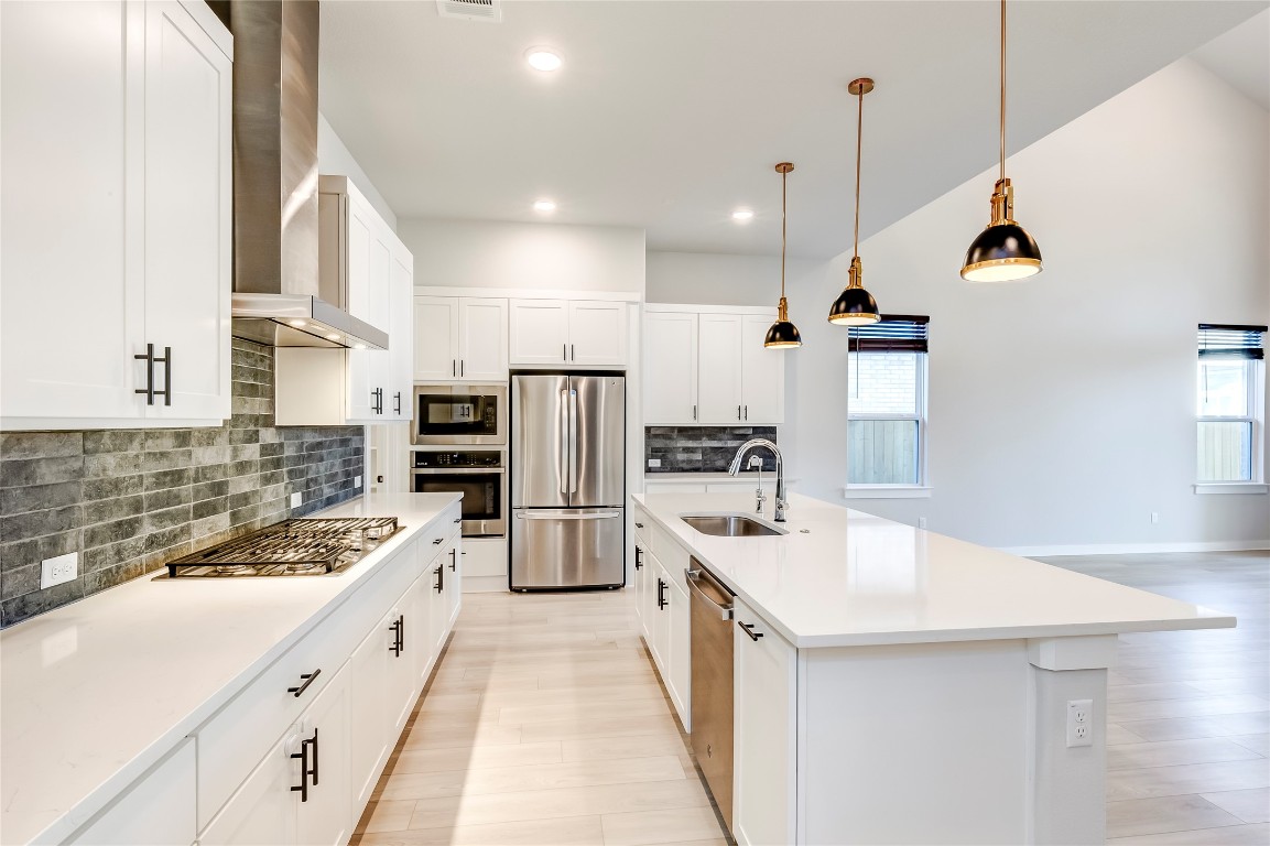 129 Cotton Tree Terrace Dripping Springs, TX 78620 - Photo 14 of 40 a kitchen with a sink a counter top space stainless steel appliances and cabinets
