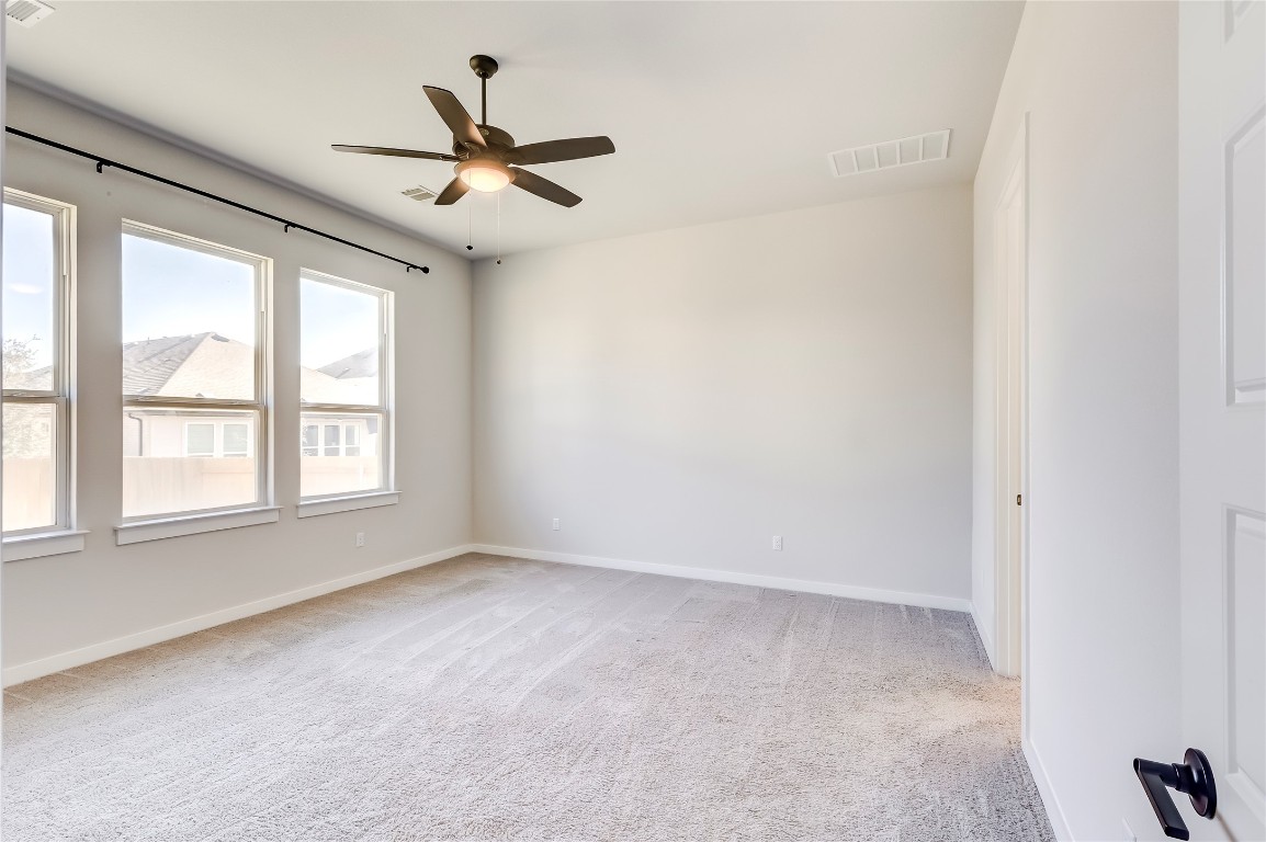 129 Cotton Tree Terrace Dripping Springs, TX 78620 - Photo 17 of 40 an empty room with ceiling fan and window