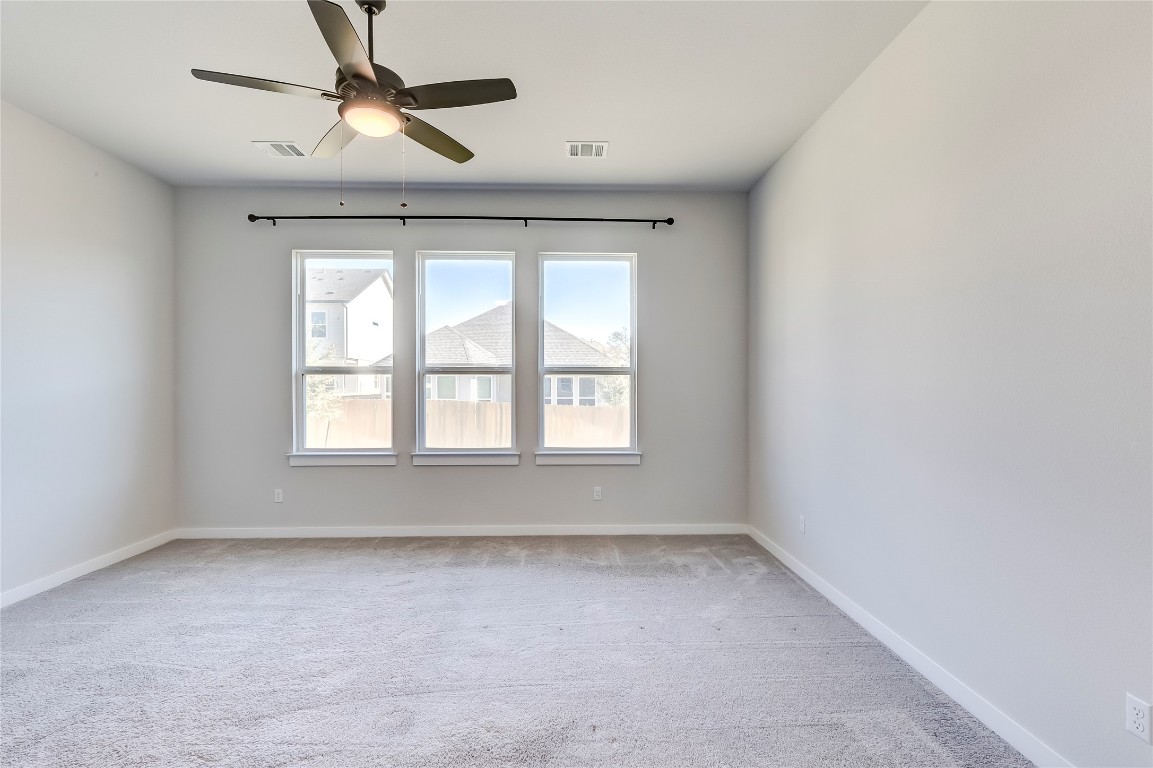129 Cotton Tree Terrace Dripping Springs, TX 78620 - Photo 20 of 40 an empty room with a window and a ceiling fan