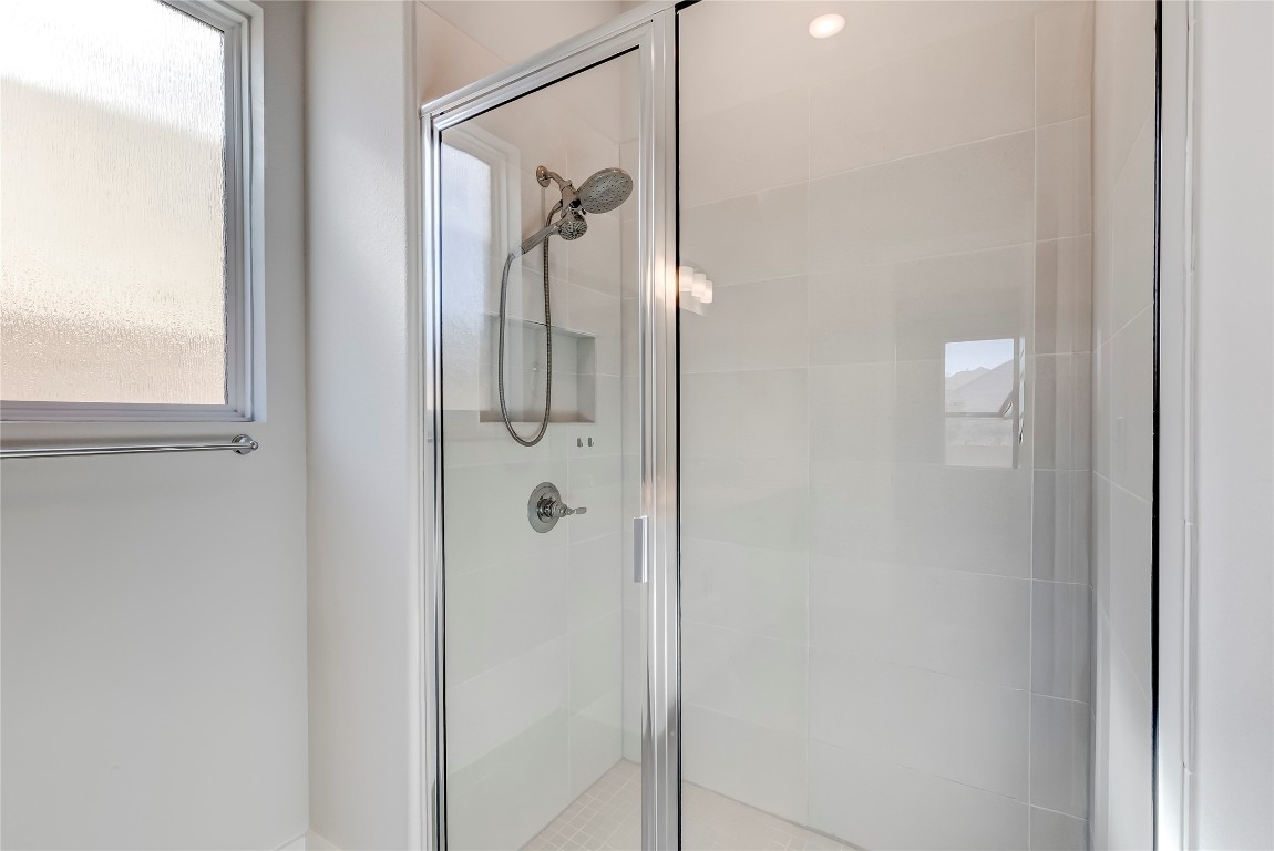 129 Cotton Tree Terrace Dripping Springs, TX 78620 - Photo 22 of 40 a bathroom with a glass shower door