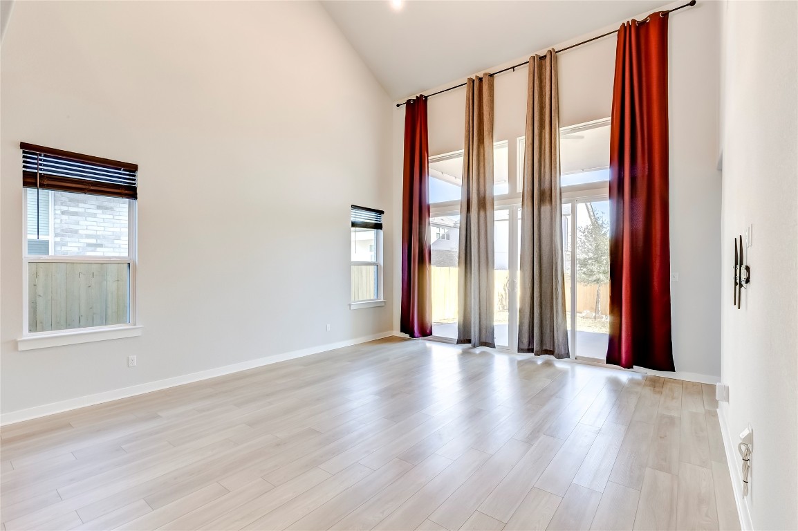 129 Cotton Tree Terrace Dripping Springs, TX 78620 - Photo 8 of 40 an empty room with wooden floor and windows