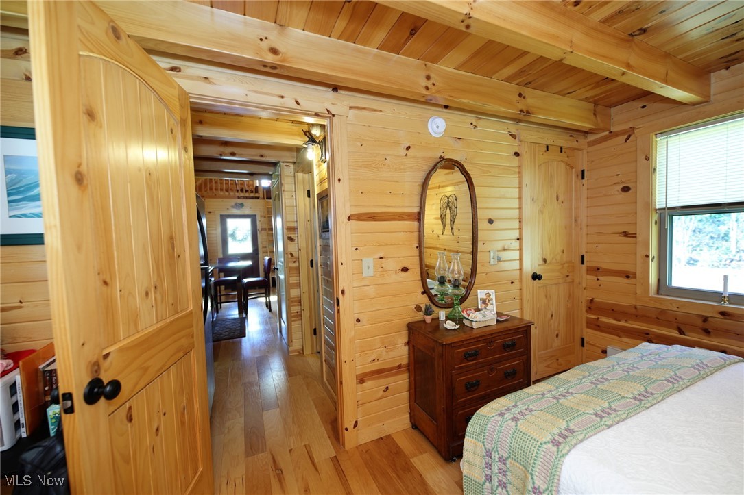 1313 Arner Road Chester, WV 26034 - Photo 29 of 46 Bedroom featuring light wood-type flooring, a wood ceiling with exposed beams, and wooden walls
