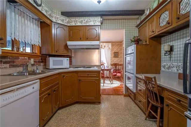 a kitchen with stainless steel appliances granite countertop a stove top oven a sink and a dining table