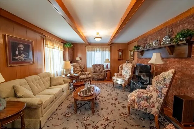 a living room with furniture a fireplace and a floor to ceiling window