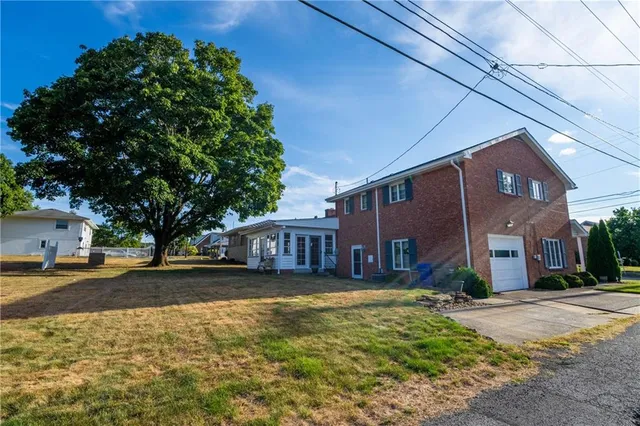 a front view of a house with a garden and trees