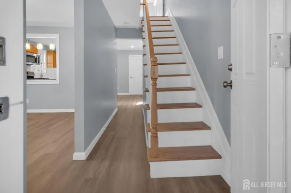 a view of staircase with wooden floor and white walls