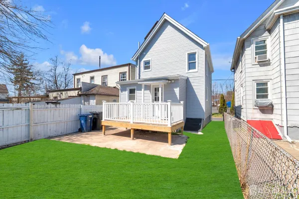 a view of house with a yard and deck