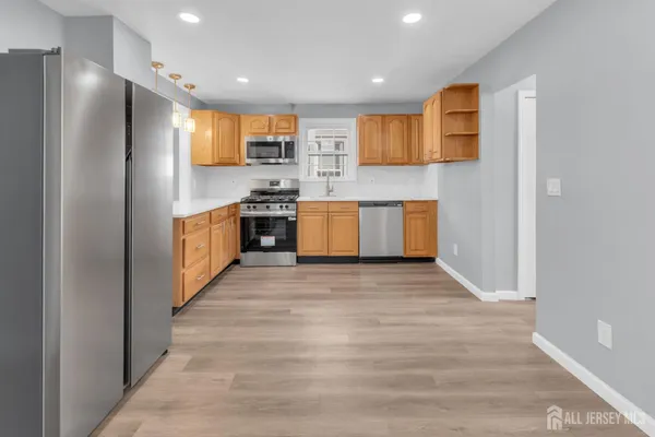 a large kitchen with stainless steel appliances granite countertop a stove and a refrigerator